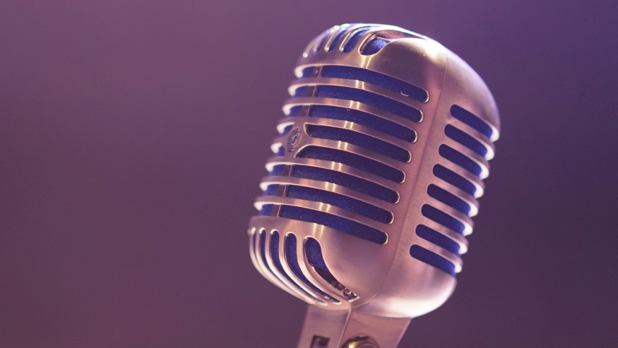 A silver microphone in a room with purple lighting.